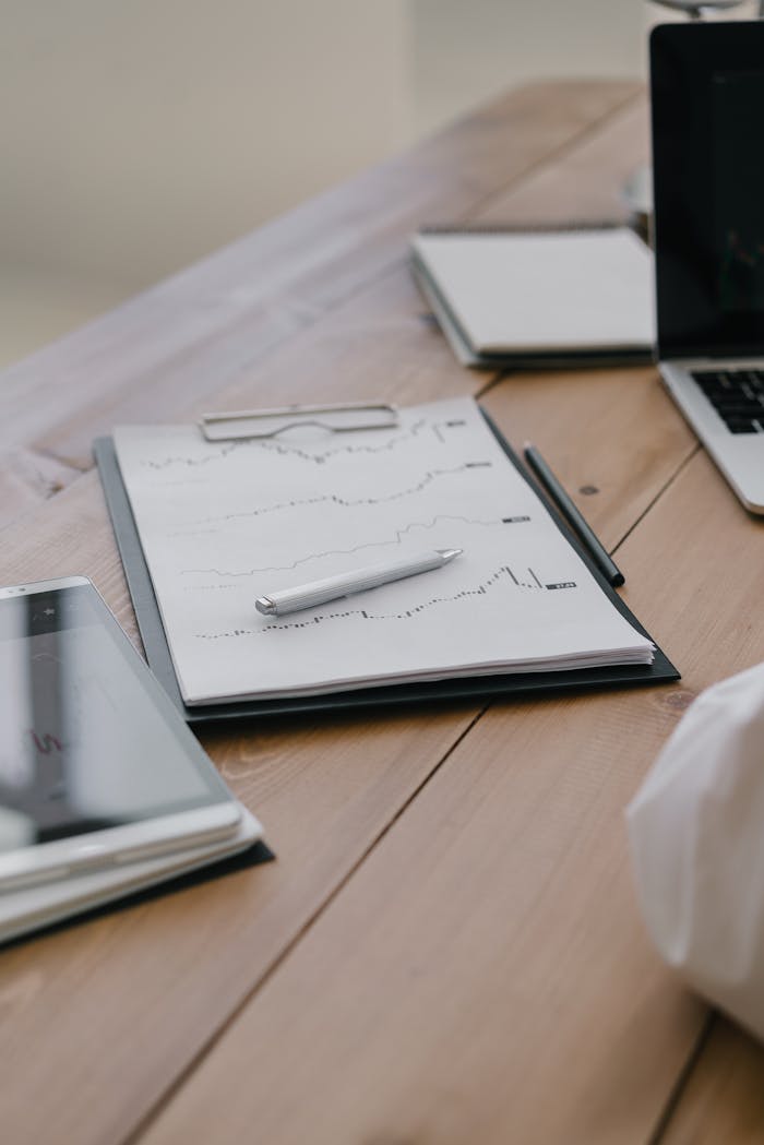 A close-up of a clipboard with documents and a pen on a wooden table, ideal for business themes.